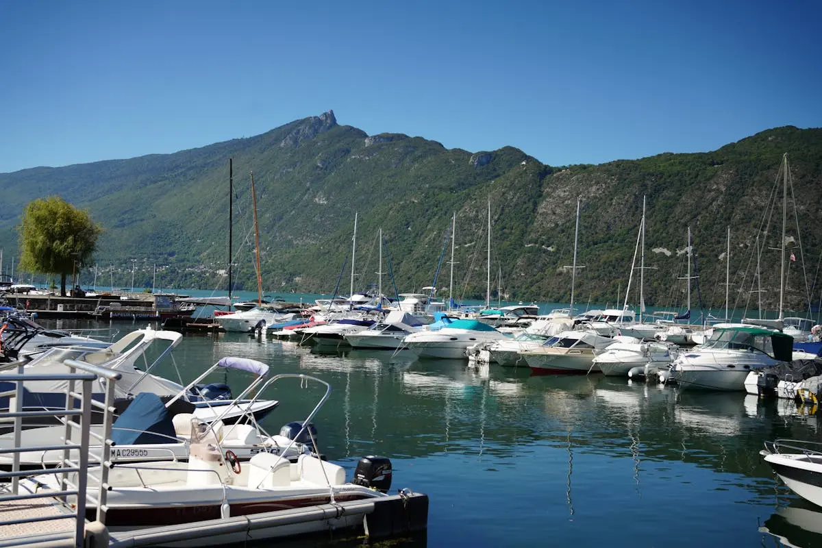 Beautiful marina with boats docked at Aix-les-Bains, France against mountainous backdrop.