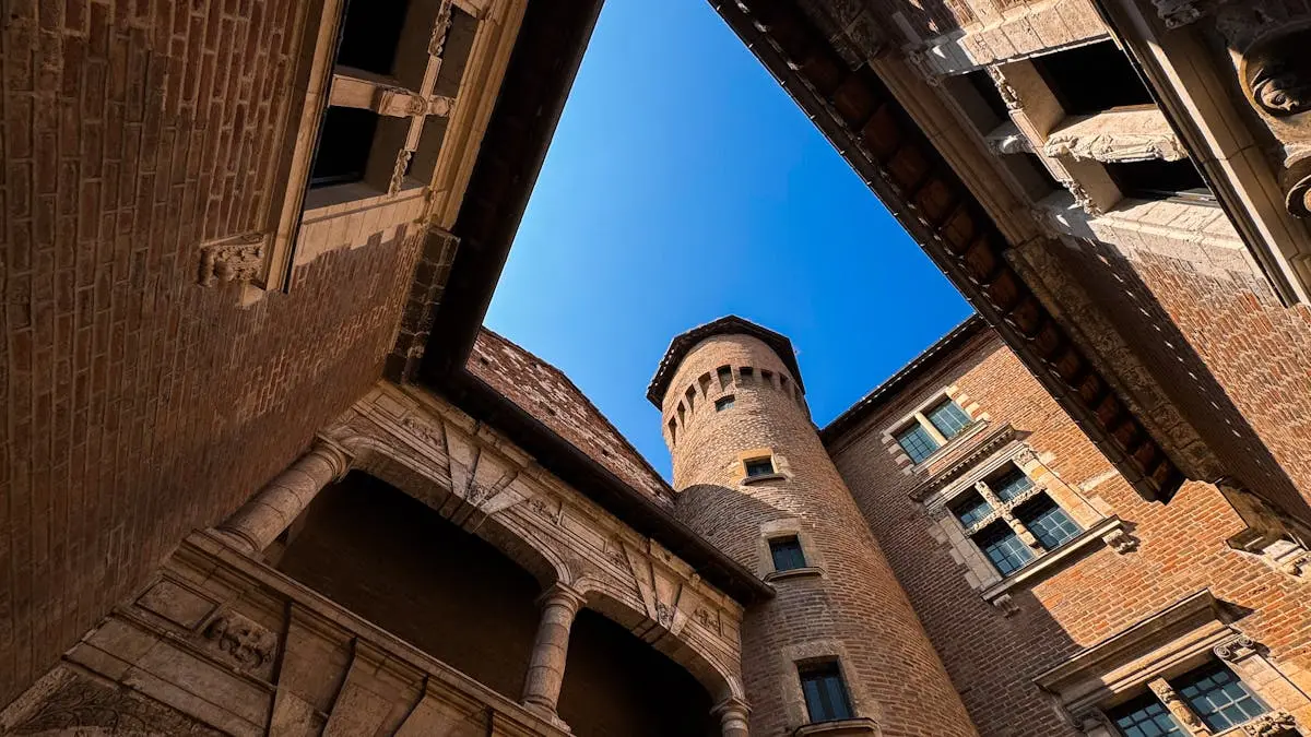 Discover the unique Gothic architecture of a historic tower in Albi, Occitanie with a clear blue sky backdrop.