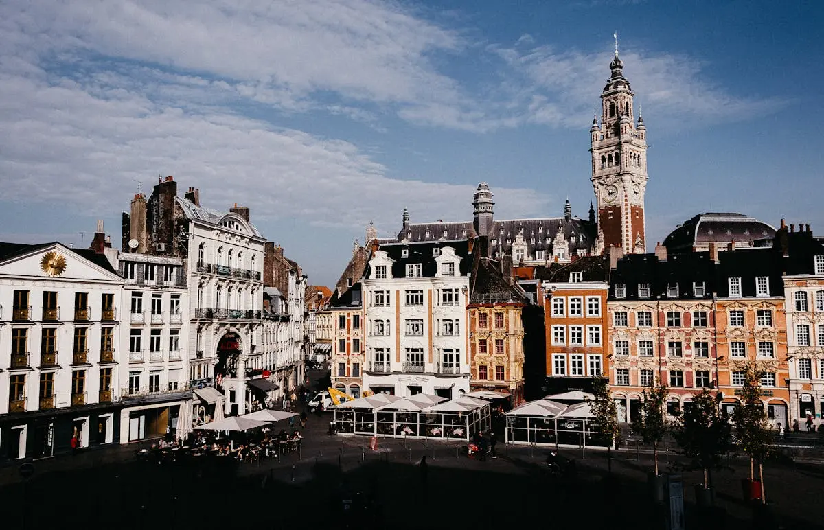 Scenic view of colorful buildings at Lille Grand Place with clear blue sky in daylight.