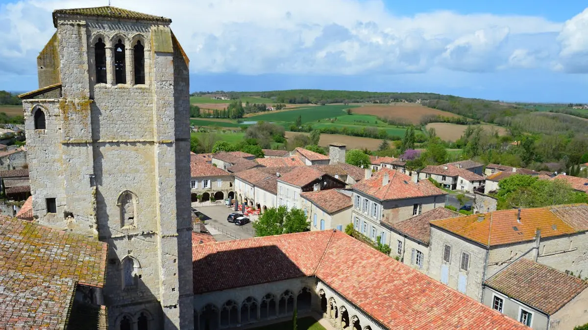 Drone view of La Romieu, France, showcasing historic architecture and countryside.