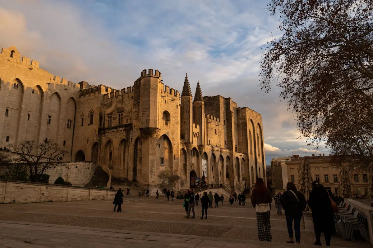 Palais des Papes d'Avignon avec visiteurs sur la place