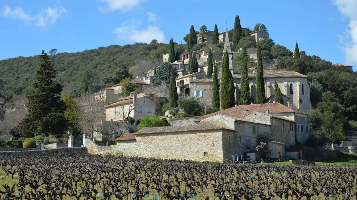 Idyllic view of La Roque-sur-Cèze village with vineyards and historic architecture in Occitanie.