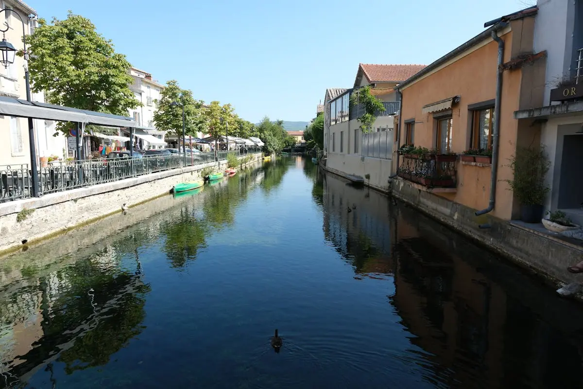 Tranquil canal scene with reflections in L'Isle-sur-la-Sorgue, France.
