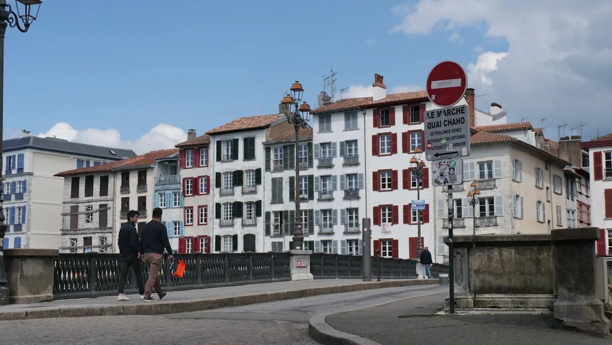 Charming street scene in Bayonne, France with traditional Basque architecture and pedestrians.