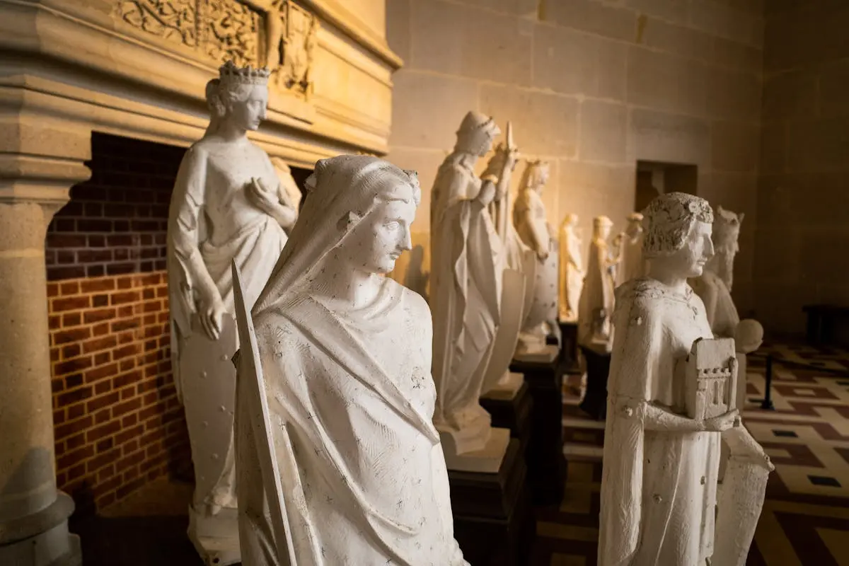 Series of historic statues on display inside Pierrefonds Castle, France, showcasing gothic architecture.