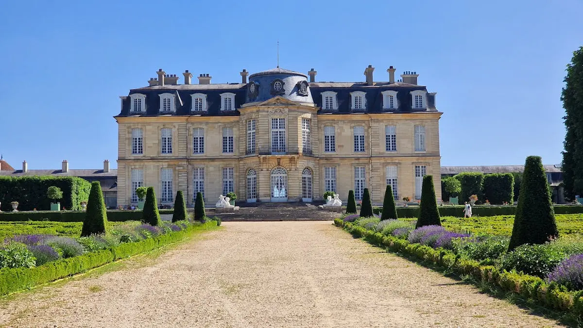 Beautiful view of Château de Champs-sur-Marne with manicured gardens under clear blue skies.