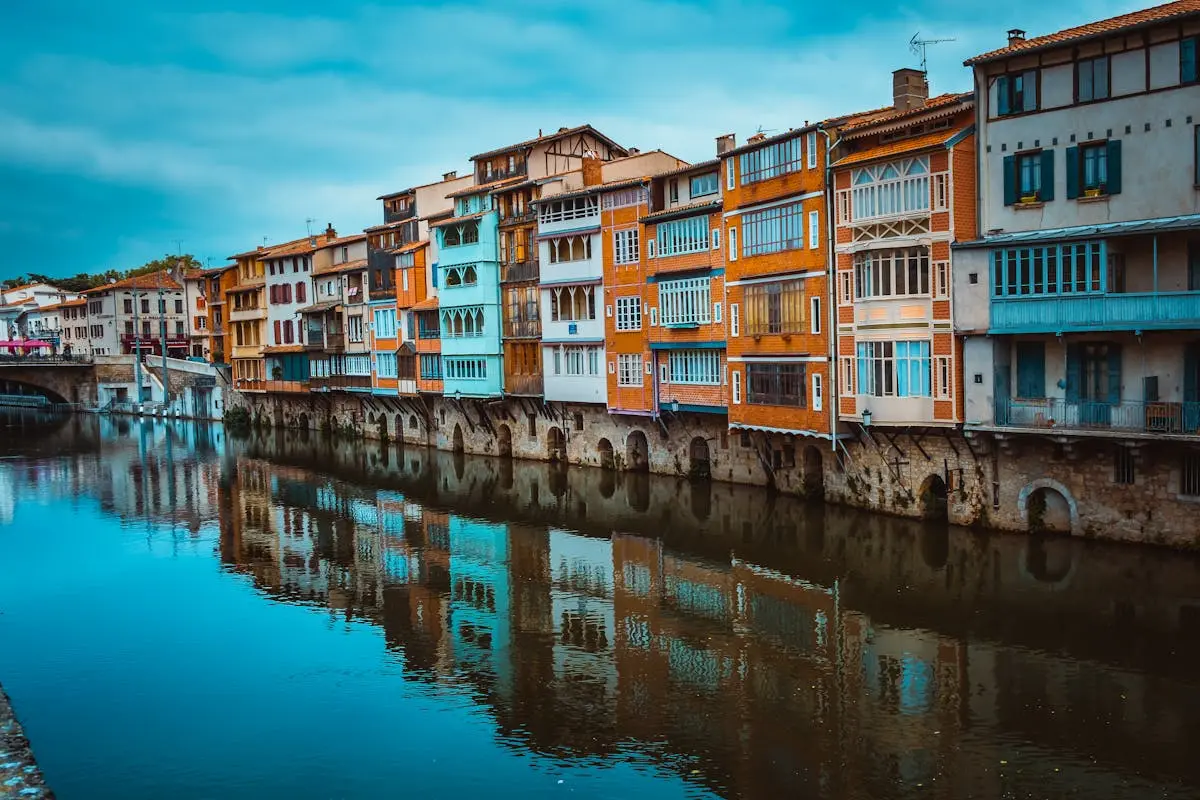 Scenic view of colorful houses reflecting in the river in Castres, France. Perfect for travel and architecture themes.