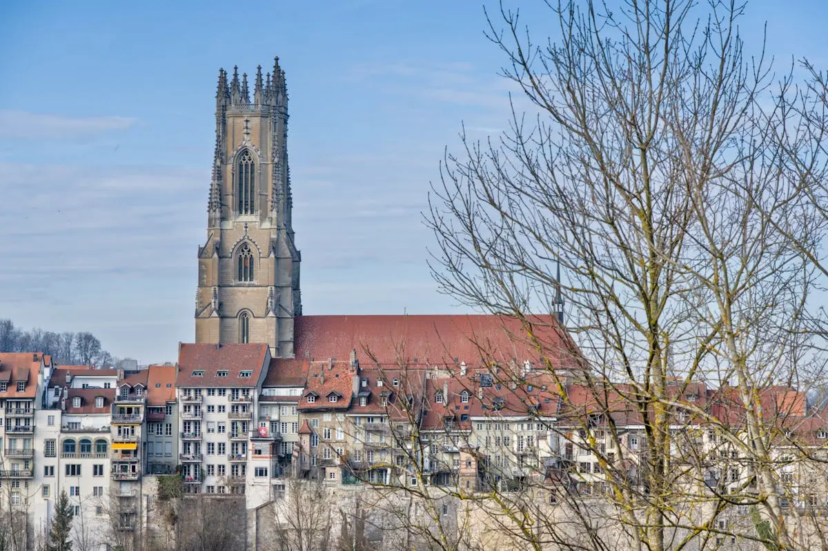 A picturesque view of Saint Nicholas Cathedral and surrounding architecture in Fribourg, Switzerland.