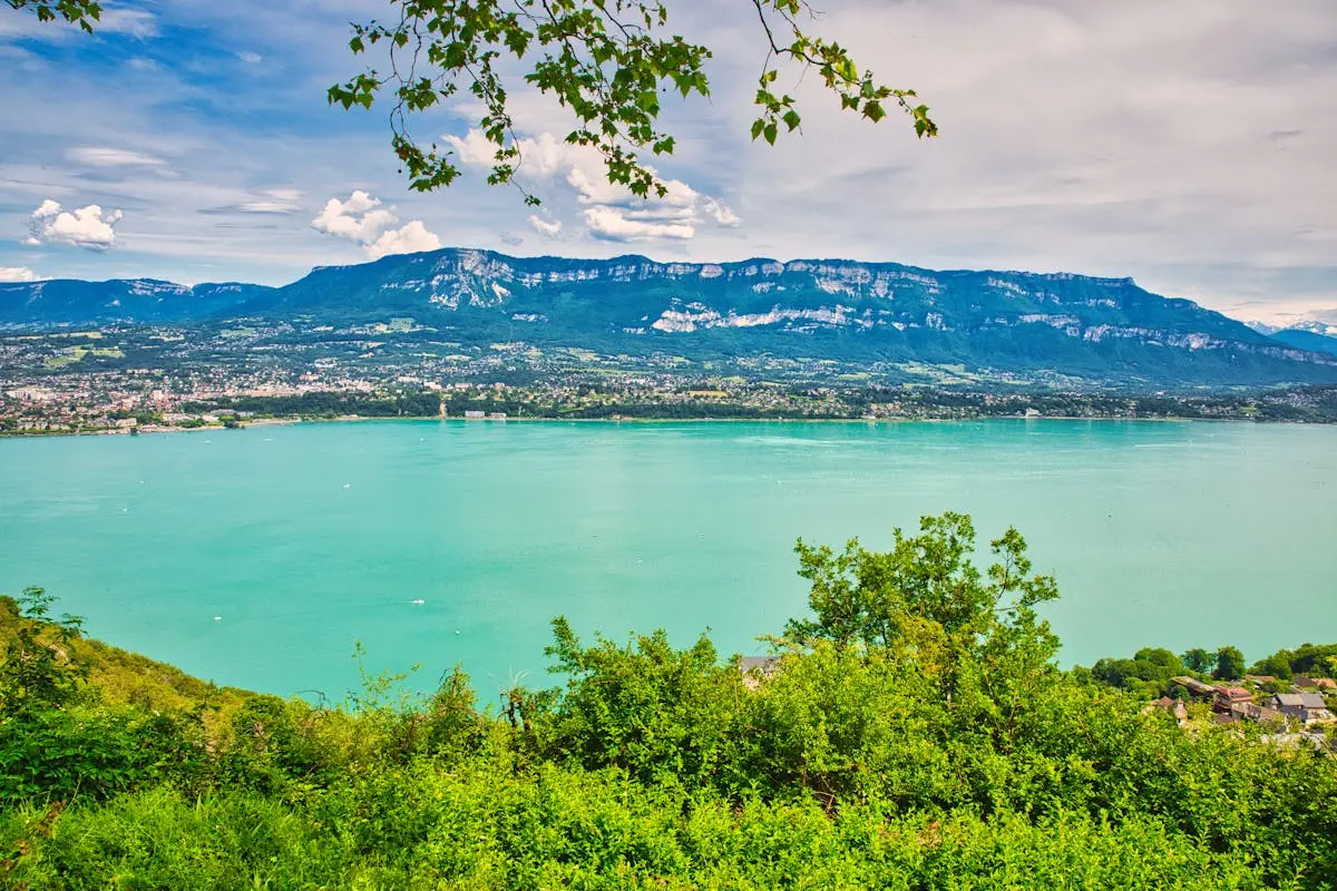 Experience the tranquil beauty of Lake Bourget surrounded by the majestic French Alps in Auvergne-Rhône-Alpes, France.