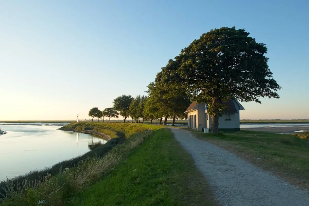 Scenic view of riverbank with trees and house in Saint-Valery-Sur-Somme, France.