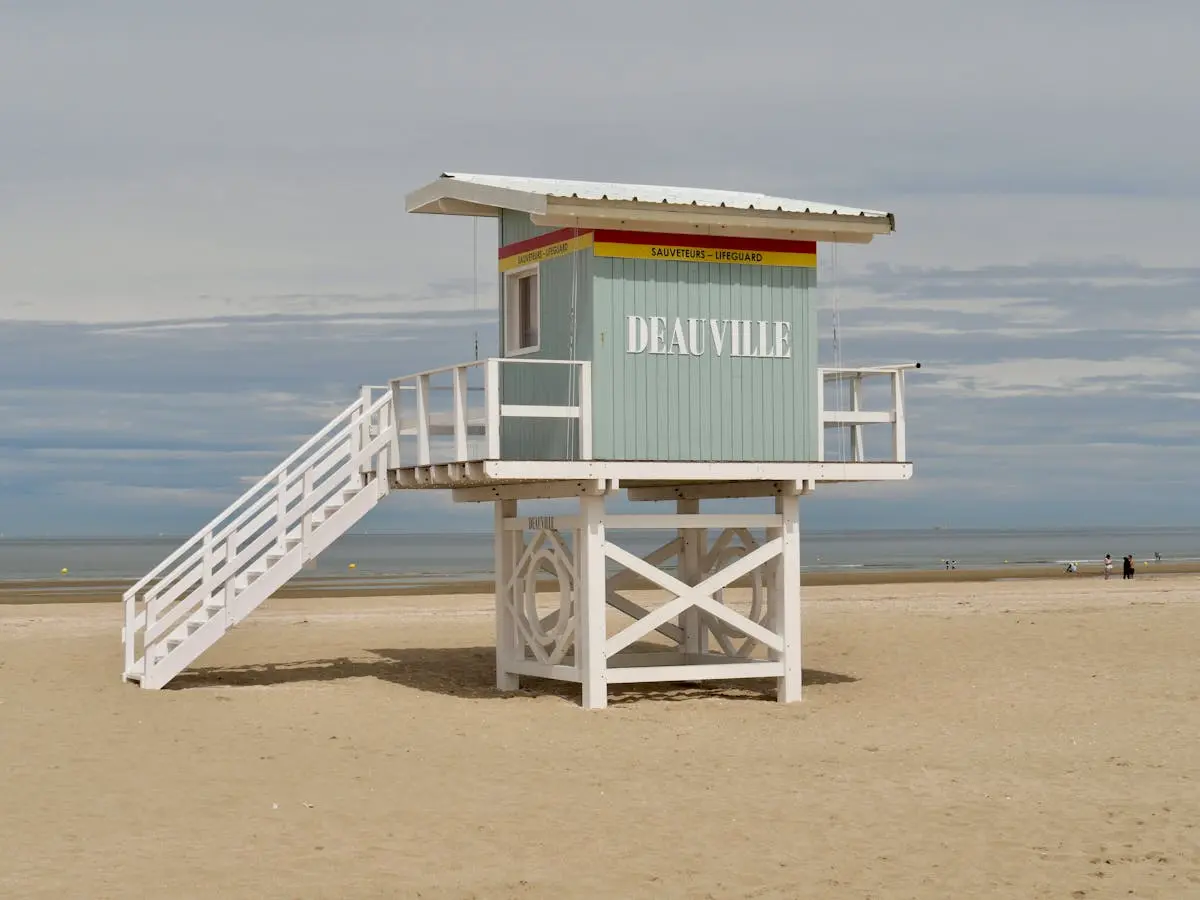 Lifeguard station on Deauville beach in Normandy, France under a cloudy sky.