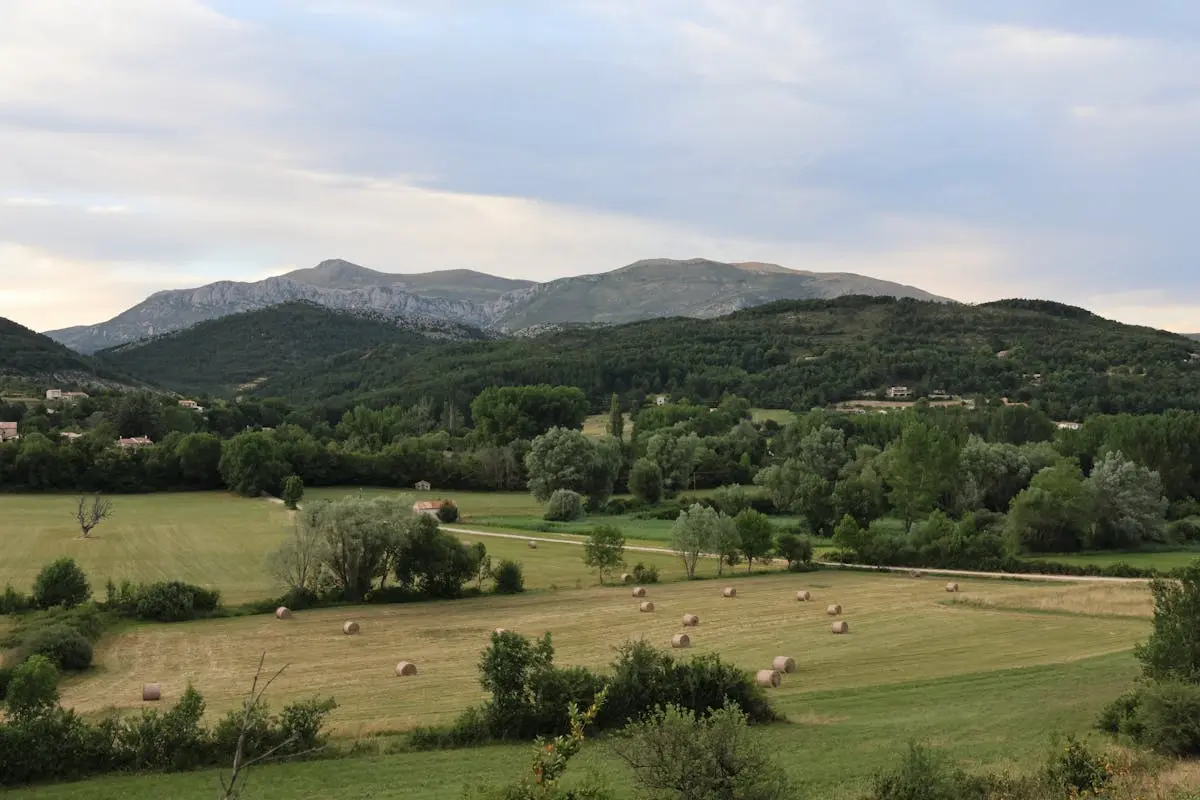 Beautiful rural landscape in La Palud-sur-Verdon, France, featuring hay bales and mountains.