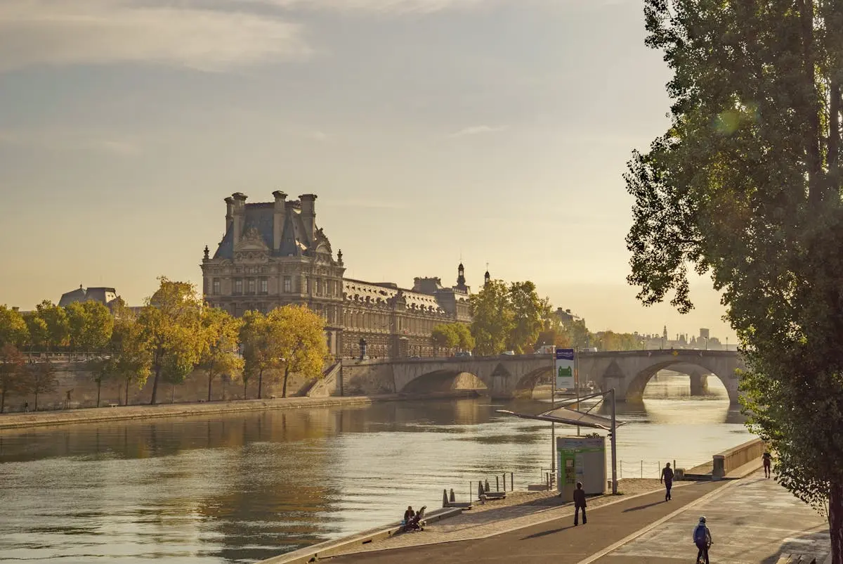 Stunning view of the Louvre and Seine River at sunset, capturing the essence of Parisian charm.