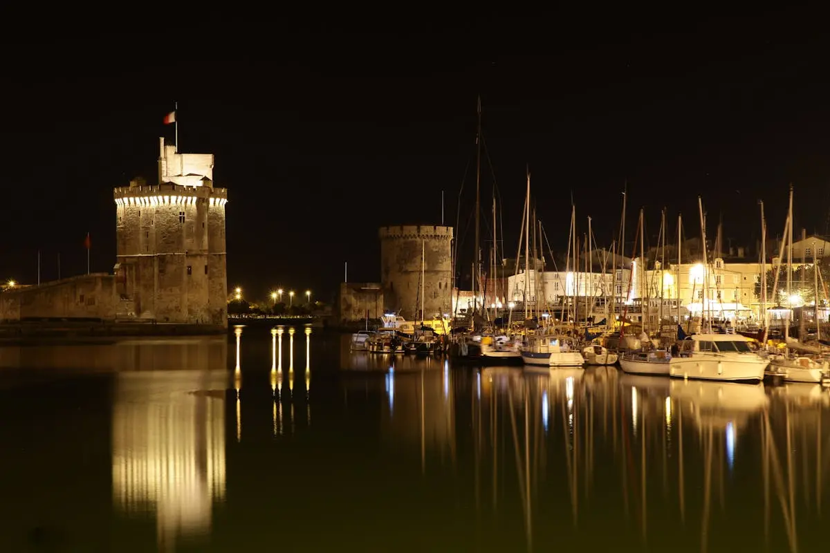 Port de La Rochelle illuminé la nuit avec reflets sur l'eau