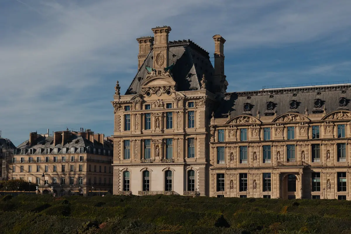 Captivating view of the elegant architecture of the Louvre Museum in Paris, under a clear blue sky.