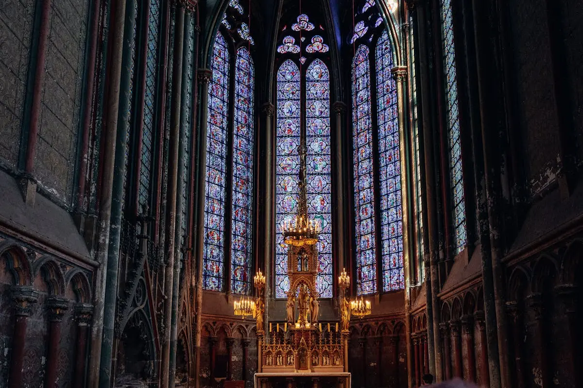 Intricate stained glass windows and altar at Amiens Cathedral, showcasing Gothic architecture.