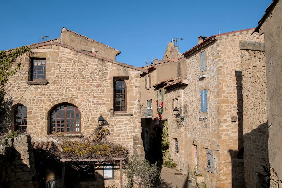 Quaint stone buildings in Miramas, capturing the rustic charm of Provence under clear blue skies.