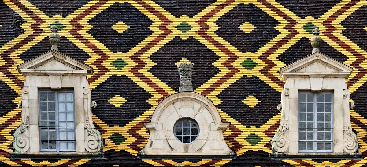 Traditional Bourgogne roof with colorful geometric patterns and classic French windows.