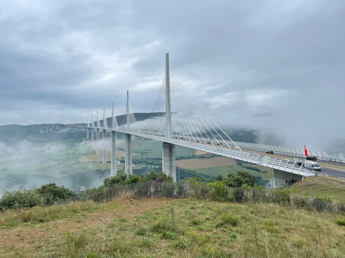 Scenic view of Millau Viaduct in Occitanie, France enveloped in fog, showcasing modern architectural beauty.
