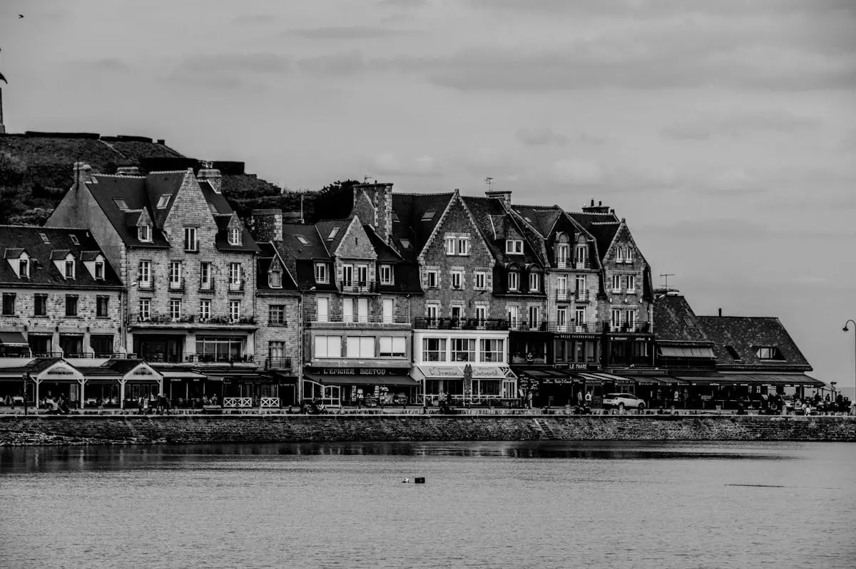 Black and white view of historic buildings along the coast in Brittany, France.