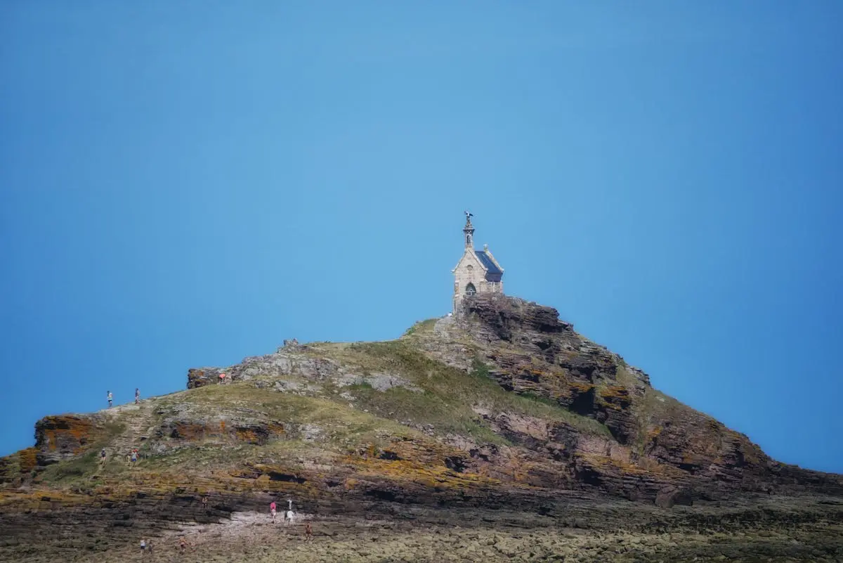 Chapel on rocky hill under blue sky in Erquy, Bretagne, France.