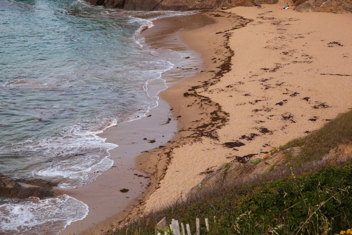 Peaceful view of a sandy beach with gentle waves in Brittany, France.