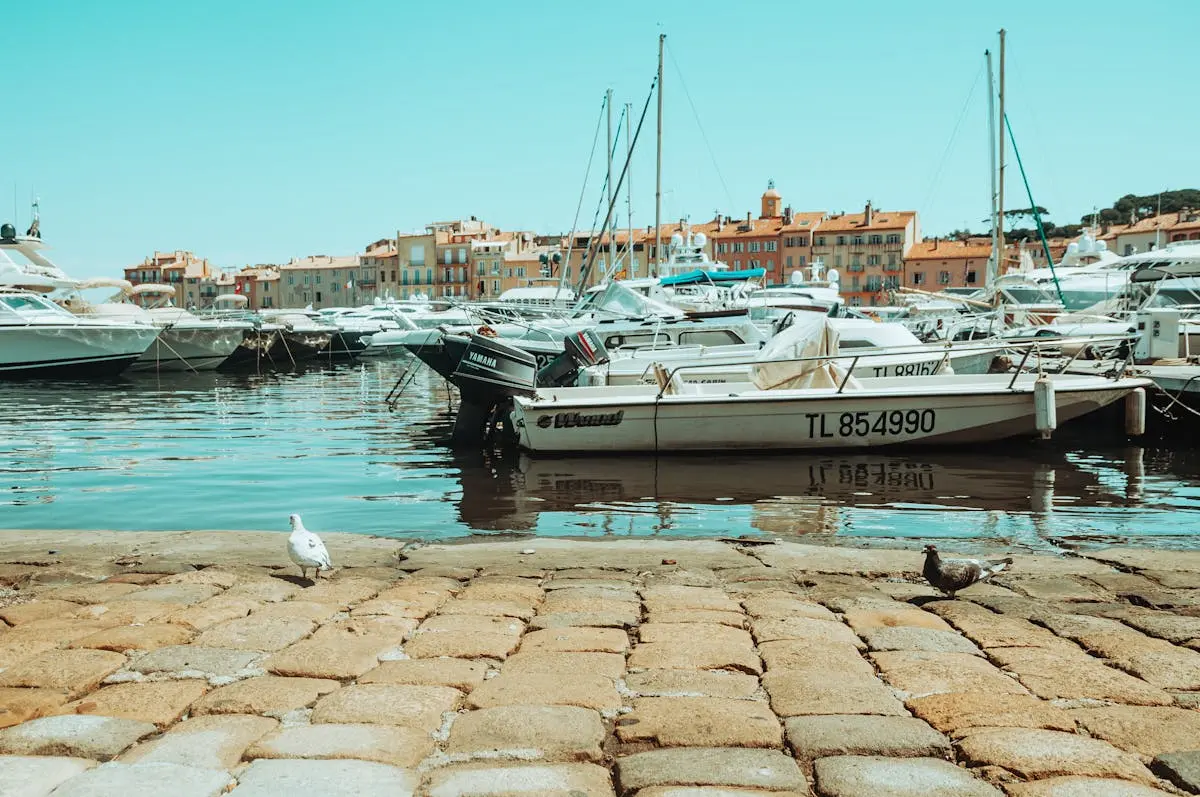 Colorful boats docked at Saint-Tropez's picturesque harbor with a clear summer sky.