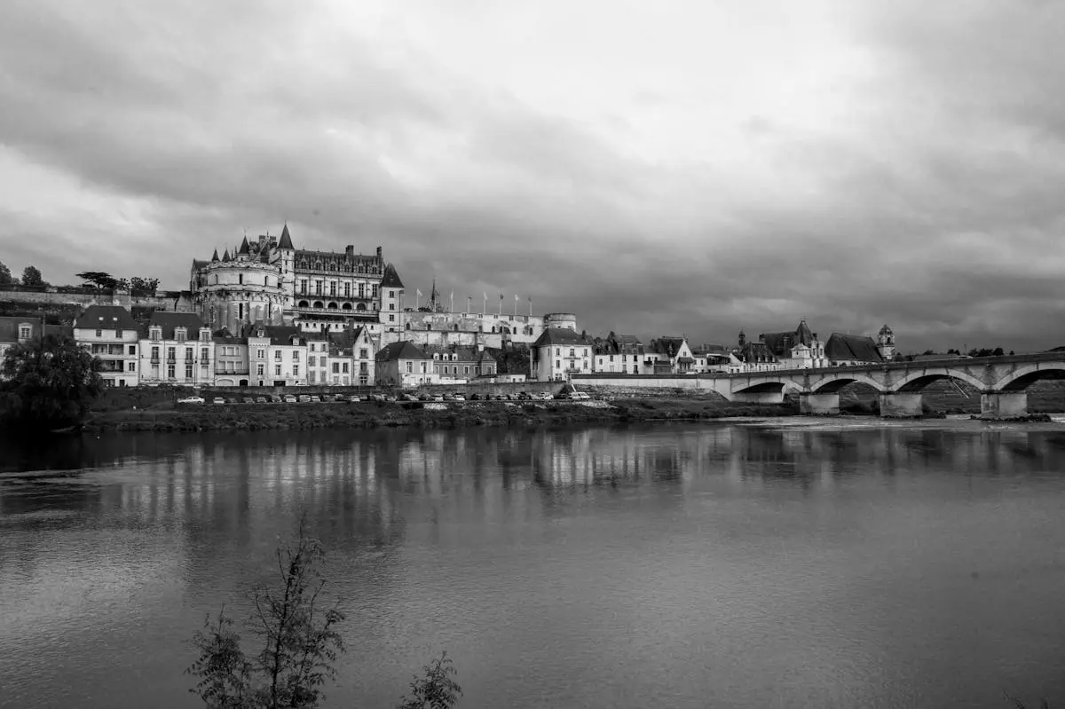 Black and white view of Château d'Amboise and bridge over the serene Loire River.