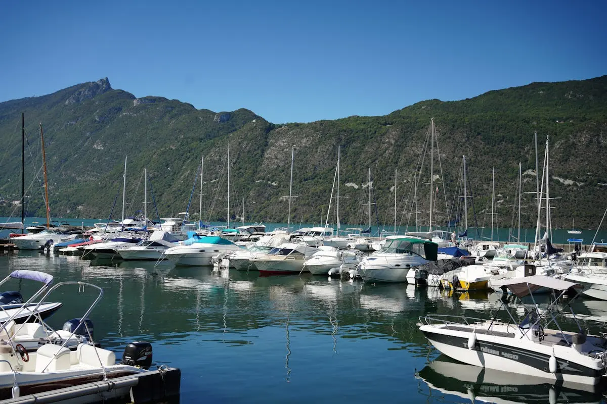 Beautiful marina in Aix-les-Bains, France with boats docked under a clear blue sky.