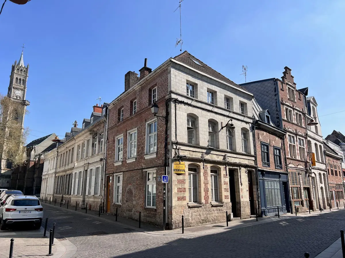 Charming view of historic buildings in Valenciennes, France under a clear blue sky.